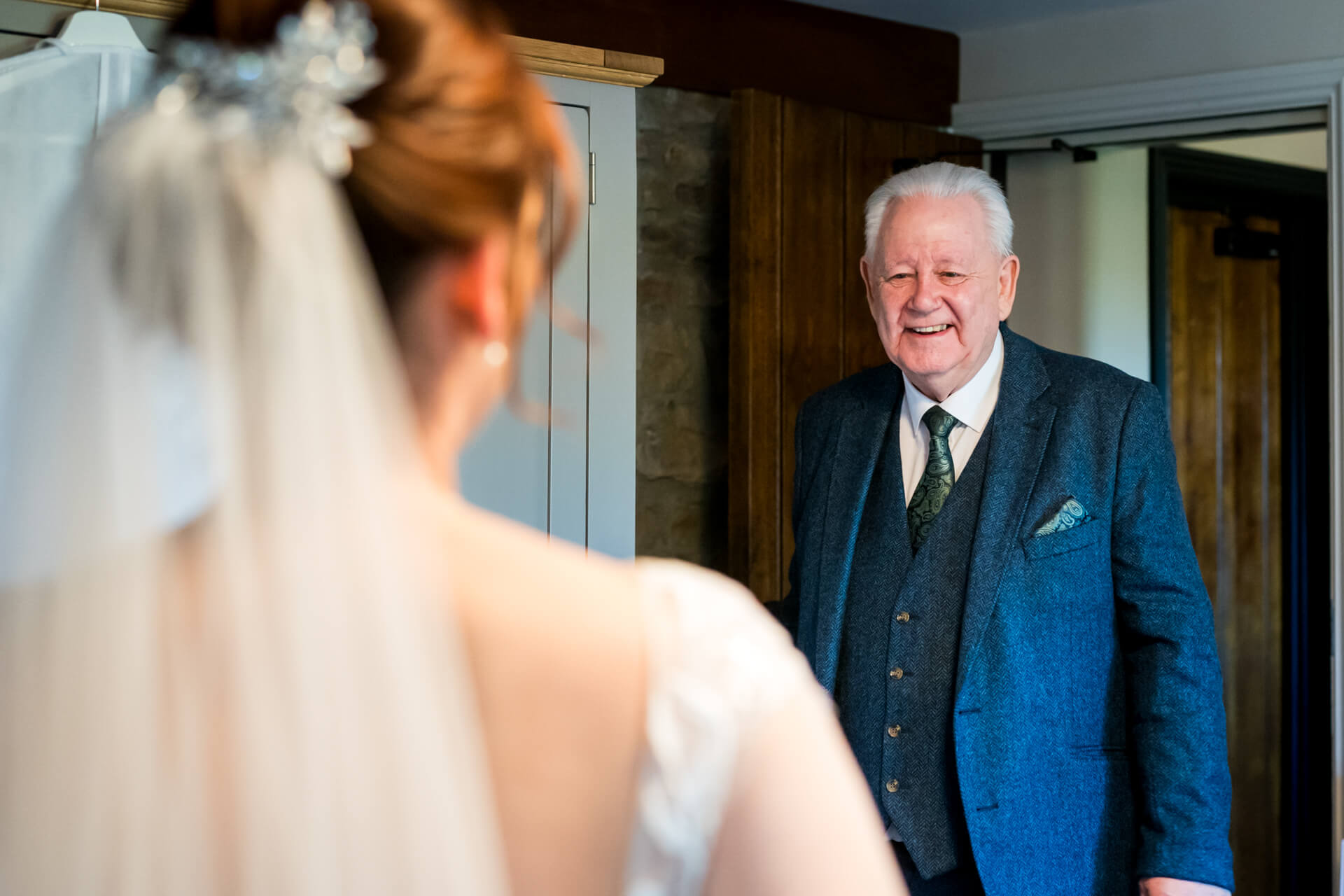 Father of the bride smiling at bride in elegant room