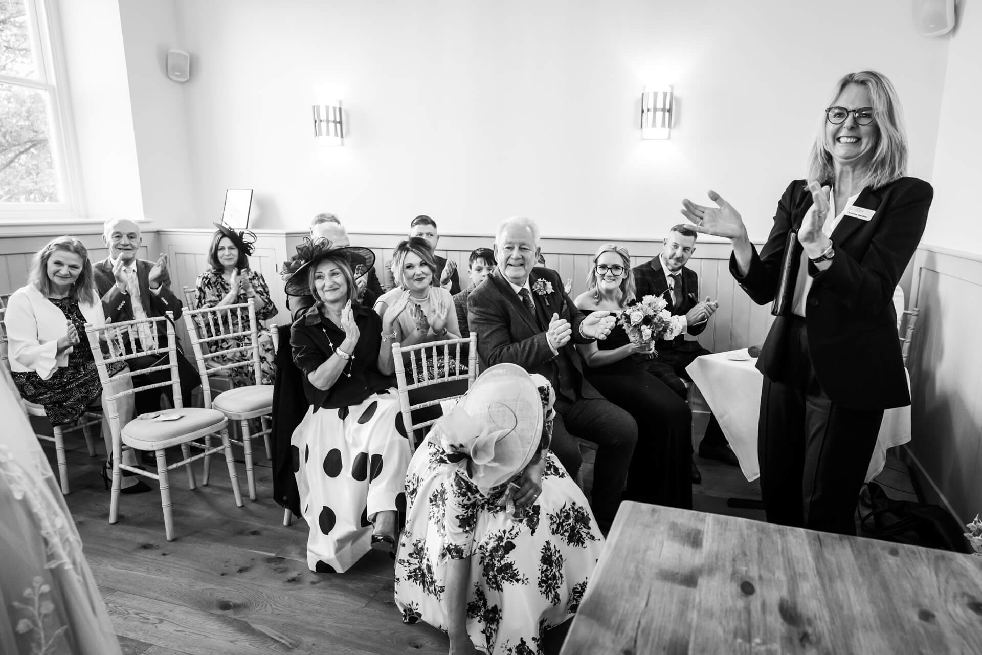 Wedding guests clapping joyfully in ceremony hall