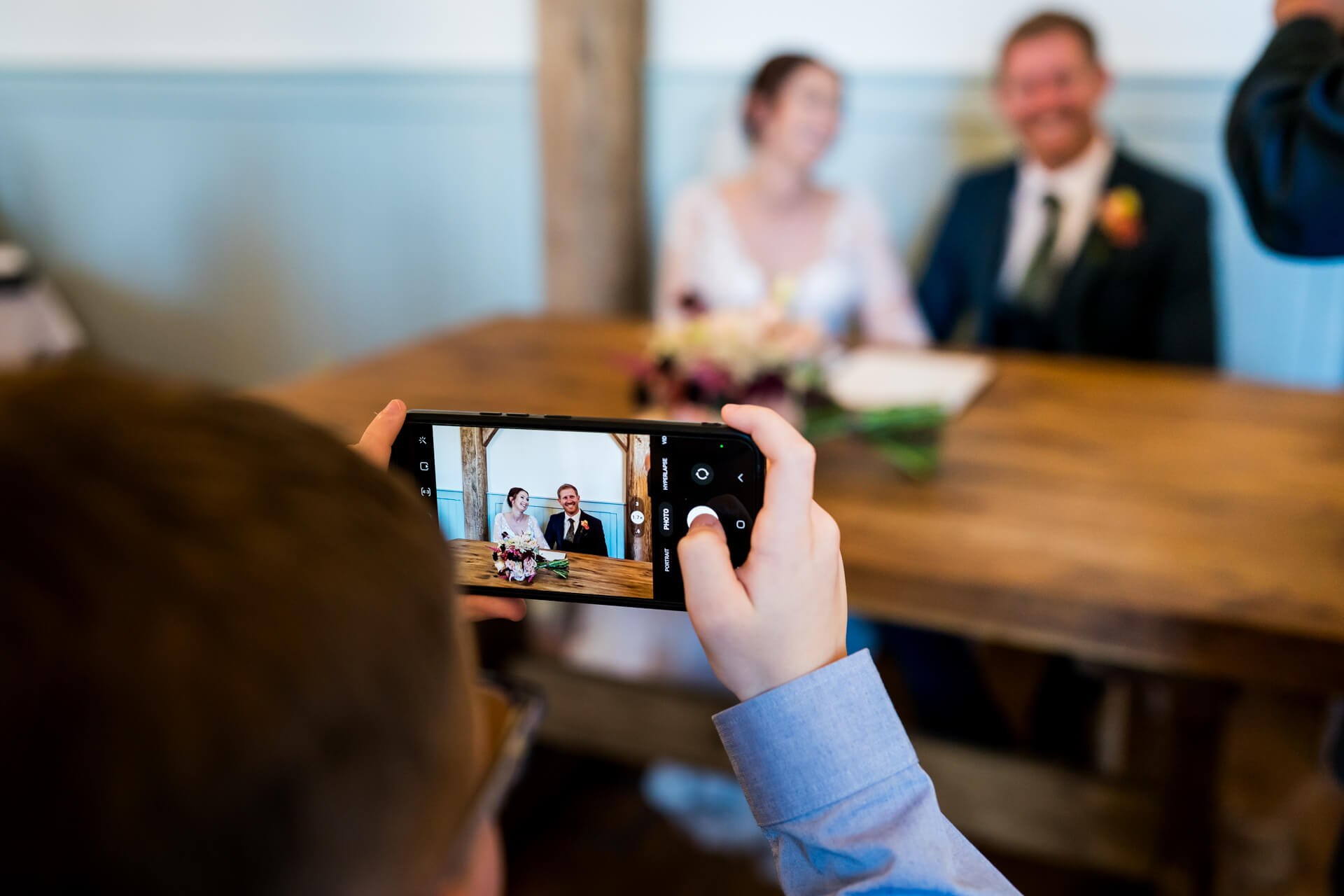 Child capturing wedding couple on smartphone camera