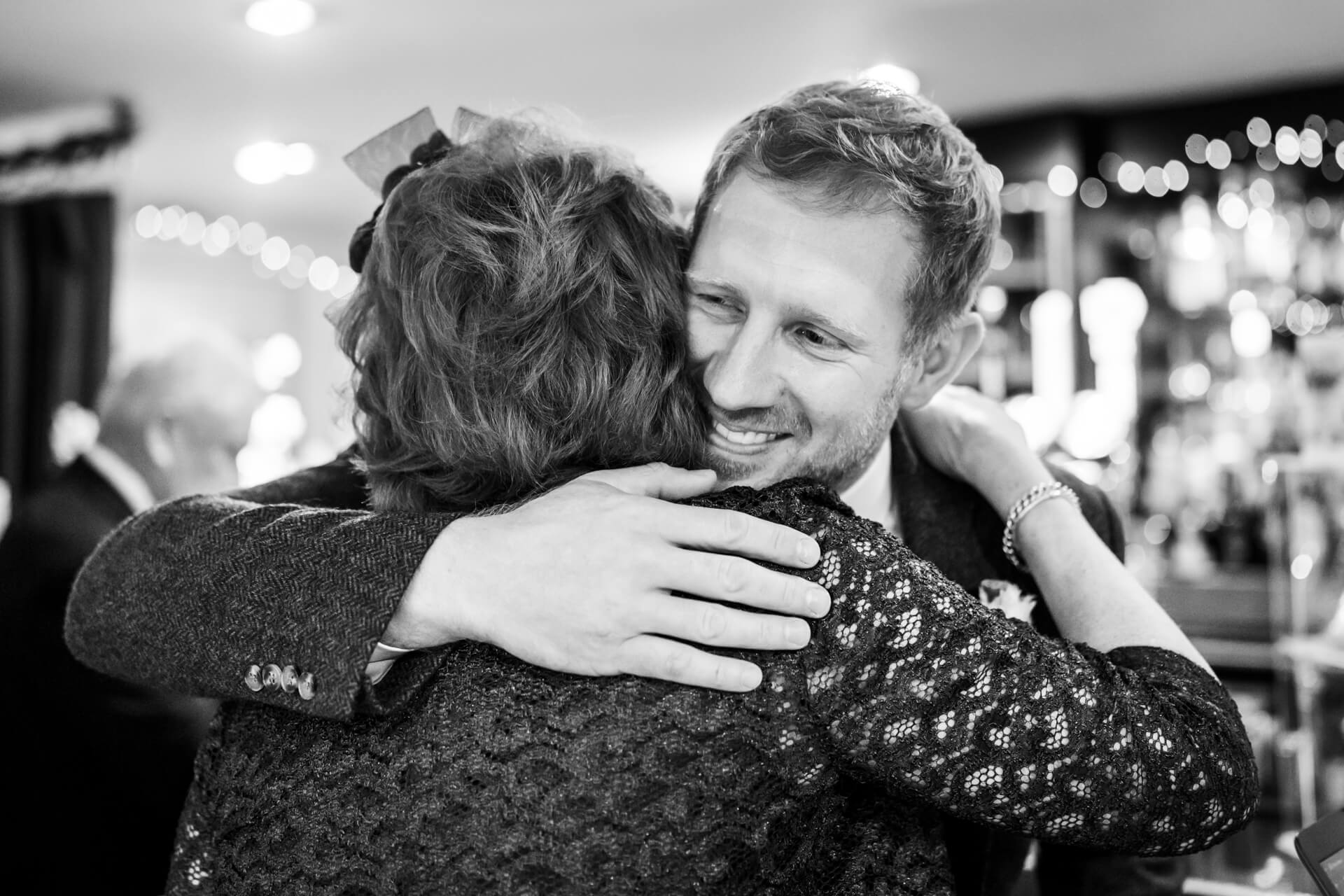 Joyful reunion hug at an elegant event, black and white