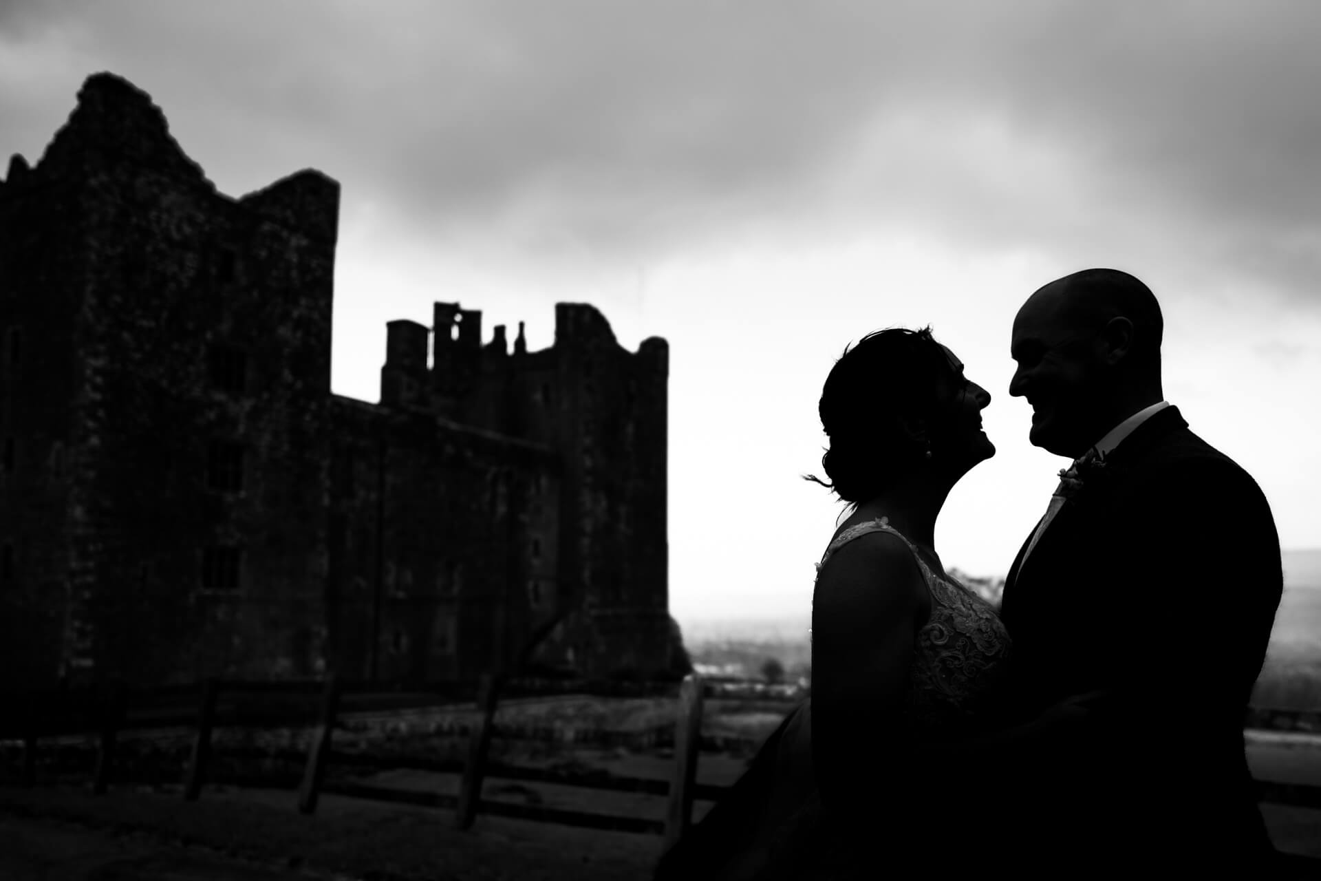 Silhouette of couple by ancient castle at dusk