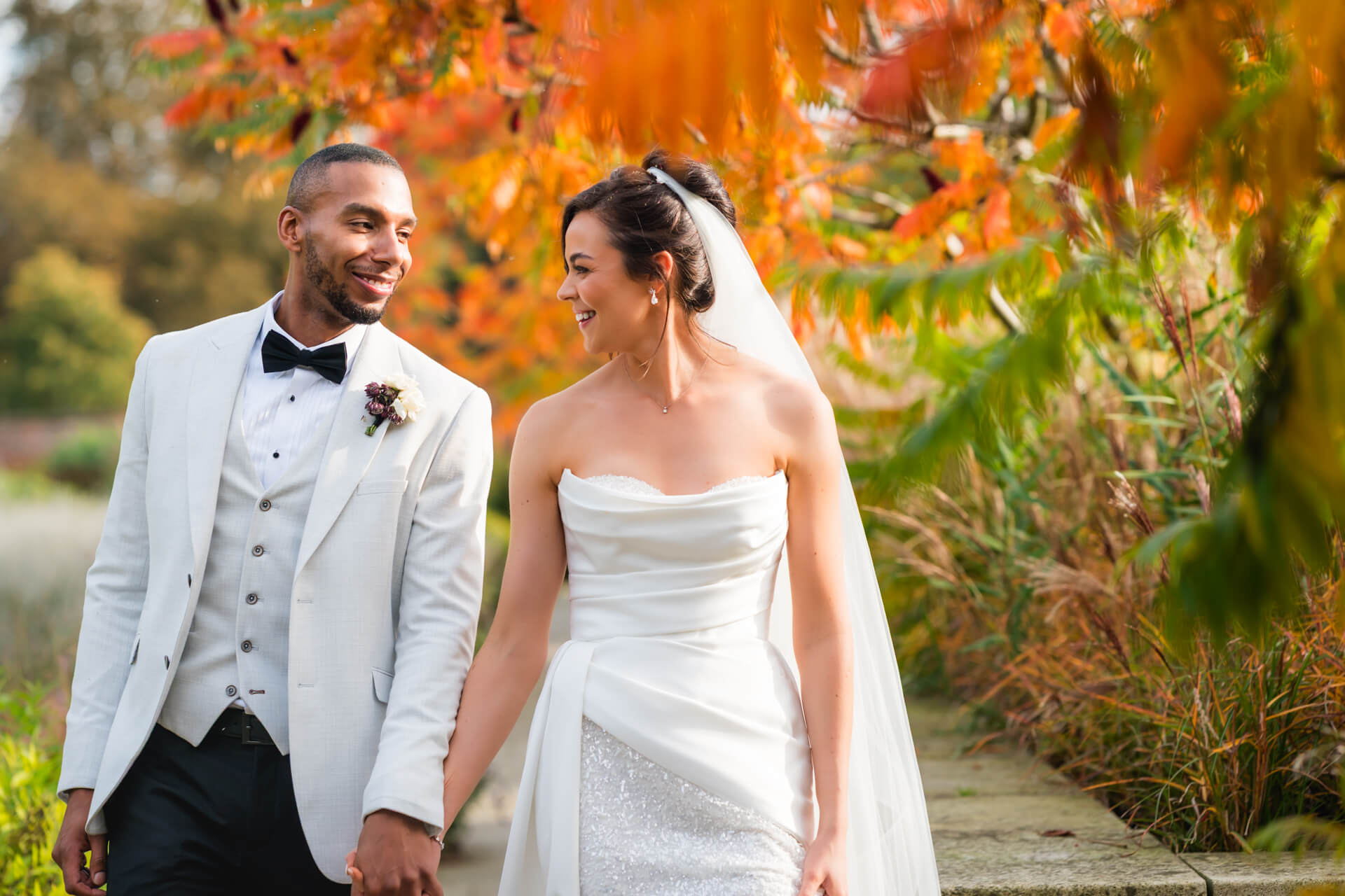 Bride and groom smiling in autumn garden